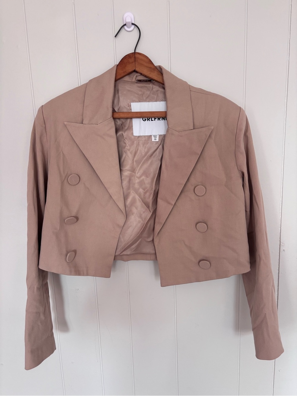 GRLFRND Power Crop is a short, double-breasted blazer in a pinkish khaki tone.